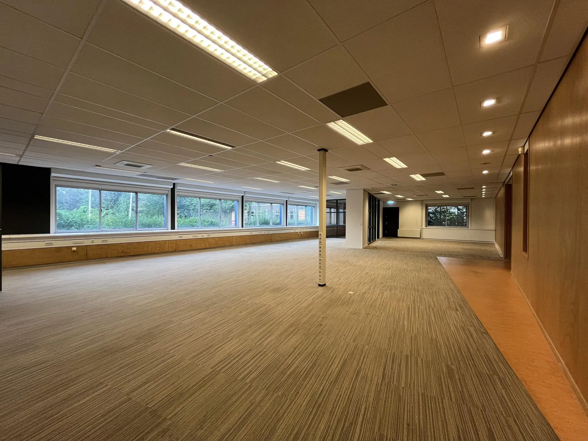 Ruime, lege kantoorruimte aan de 2e Daalsedijk met grote ramen en systeemplafond.